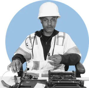 Tavon Williams at a fibre splicing bench, in a hard hat and high-visibility vest.